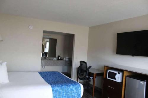 a hotel room with a bed and a flat screen tv at Travelodge by Wyndham Cedar City in Cedar City