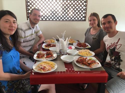 a group of people sitting around a table with plates of food at Aa Inn in Trincomalee