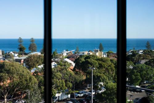 a view from a window of a city and the ocean at Anchorage Apartments Hampton in Melbourne