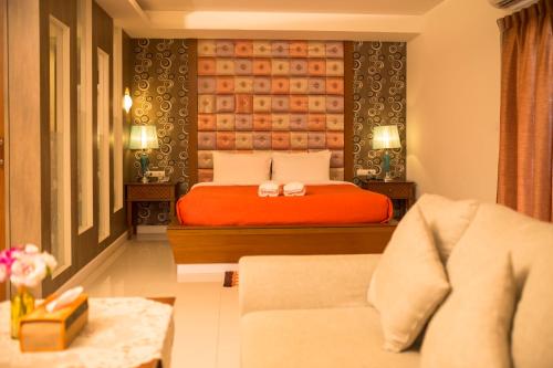 a hotel room with a bed and a couch at Kwan Ruen Park in Nakhon Ratchasima