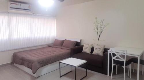 a living room with a couch and a table at Condo C4 IMPACT in Nonthaburi
