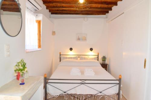 
a bedroom with a white bed and white walls at Palaios Rooms in Plaka Milou
