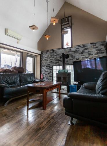 a living room with a couch and a table at Niseko Ski Lodge - Hirafu in Kutchan