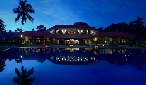 a building with a pool of water at night at Taj Fort Aguada Resort & Spa, Goa in Candolim