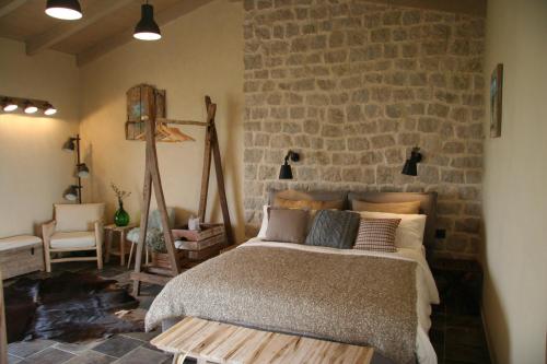 - une chambre avec un lit et un mur en briques dans l'établissement B&B Torre Dell'Angelo, à Citta' Sant'Angelo