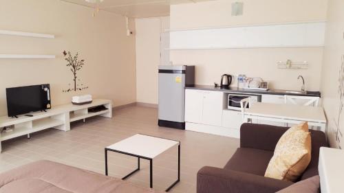 a living room with a couch and a kitchen at Popular Condo P1 in Nonthaburi