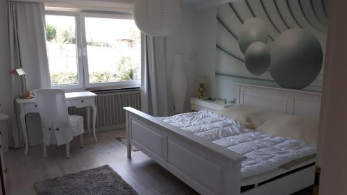 a bedroom with a bed and a desk and a window at FeWo Gabriela in Windhausen
