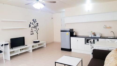 una cucina e un soggiorno con mobili bianchi e una TV di Popular Condo C8 a Nonthaburi
