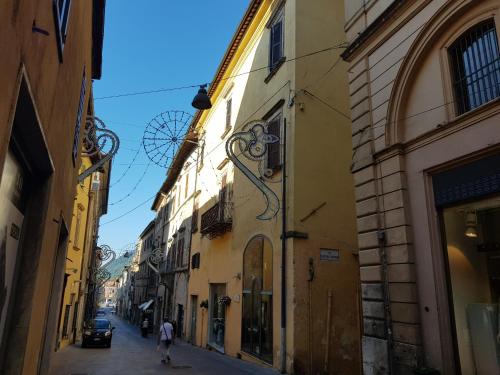 a person walking down a street between two buildings at il CAPITELLO in Rieti
