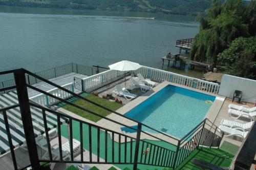 a swimming pool next to a body of water at Casa Yuppy Du in Eşelniţa