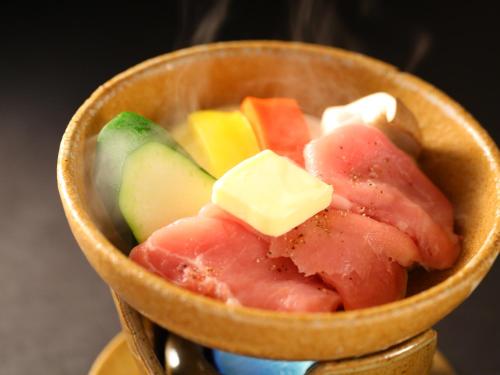 a wooden bowl filled with different types of fruit at Besshoonsen Nanjyo Ryokan in Ueda