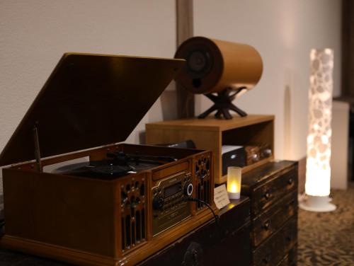 a room with a desk with a television and a lamp at Besshoonsen Nanjyo Ryokan in Ueda
