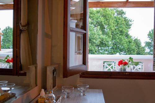 a kitchen with two windows with wine glasses on a counter at Sea and Creek in Katelios