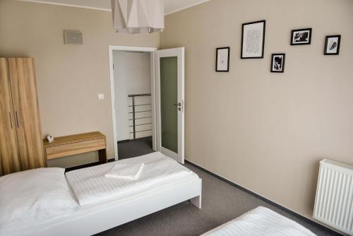 een slaapkamer met een wit bed en een spiegel bij Penzión Fonte in Radava