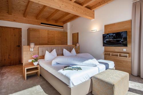 a bedroom with a bed with a tv on the wall at GOTTHARD - FINE LIVING APARTMENTS in Seefeld in Tirol