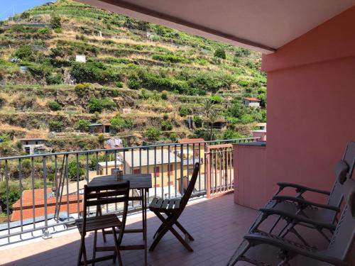 a balcony with a table and chairs and a mountain at Cà de Lelio in Manarola
