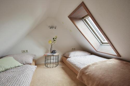 a attic bedroom with two beds and a window at Reiterhof Zwei Linden in Melle