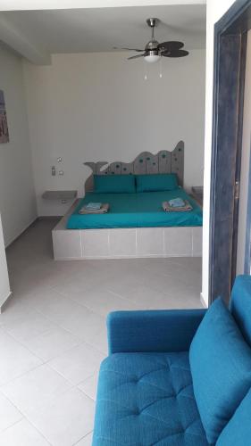 a bedroom with a blue bed and a couch at B&B Sereia Azul Boa Vista in Sal Rei