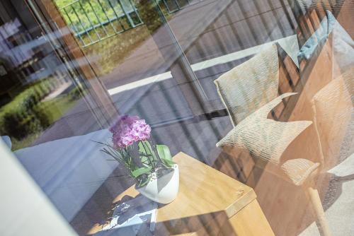 a vase with purple flowers sitting on a table at GOTTHARD - FINE LIVING APARTMENTS in Seefeld in Tirol