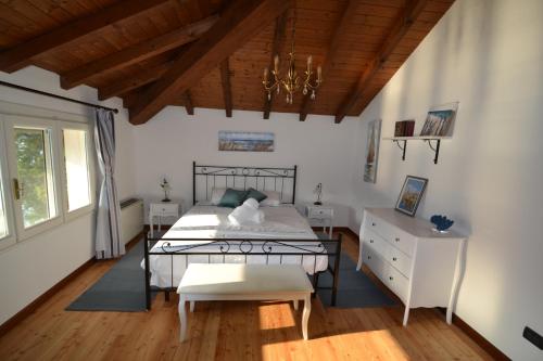 Villa Rina Deluxe and Cottage في بورتو سرسيو: غرفة نوم بسرير وسقف خشبي
