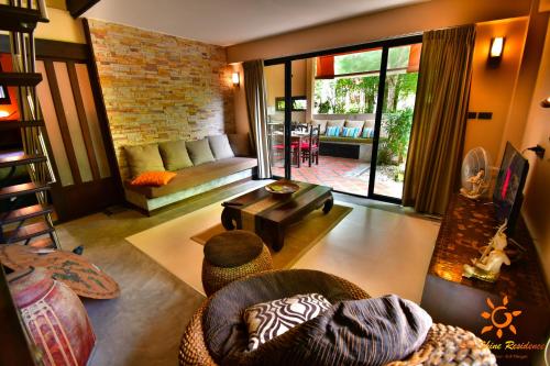 a living room with a couch and a table at Sunshine Residence in Baan Tai