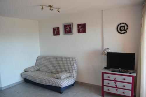 un salon avec une chaise et une télévision dans l'établissement Vue mer et plages à pied, à Sète