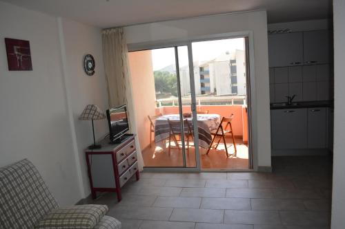 d'un salon avec une porte coulissante en verre s'ouvrant sur un balcon. dans l'établissement Vue mer et plages à pied, à Sète