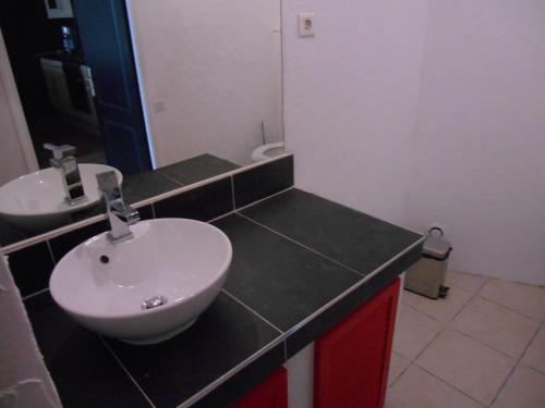 W łazience znajduje się biała umywalka i lustro. w obiekcie attitude zen w mieście Saint-Laurent-le-Minier
