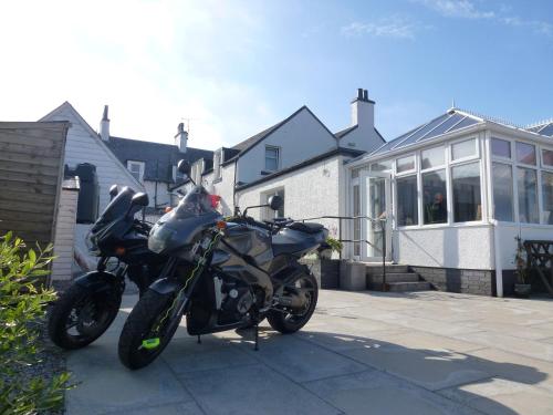 a motorcycle parked in front of a house at Argyll Hotel in Bellochantuy