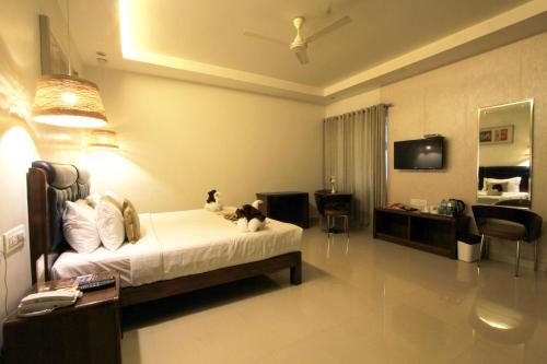 a bedroom with a bed with two cats sitting on it at Stay Comfort in Visakhapatnam
