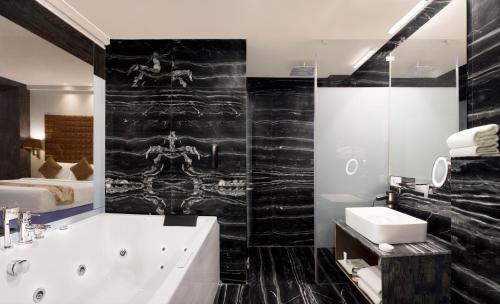 a bathroom with a bath tub and a sink at Regenta Central Hotel & Convention Centre Nagpur in Nagpur