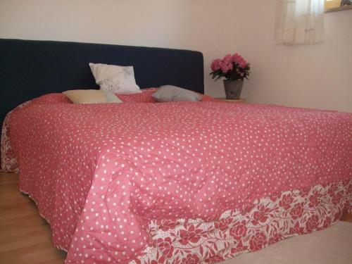 a bed with a red and white comforter on it at Ferienwohnung Eyssel in Isny im Allgäu