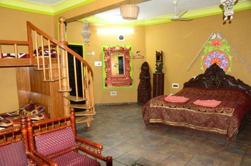 a bedroom with a bed and a staircase in a room at Nakhrali Dhani Resort in Indore