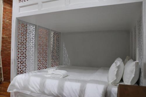 a white bed with towels on it in a room at Lanna Oriental Hotel in Chiang Mai