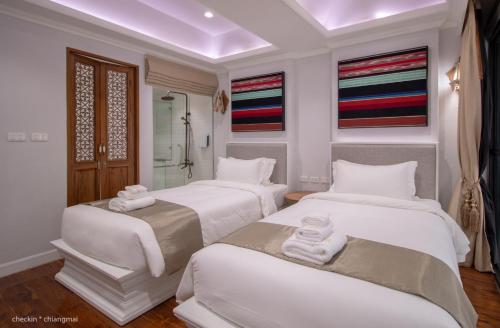 a room with three beds with towels on them at Lanna Oriental Hotel in Chiang Mai