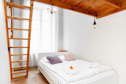 uma cama branca num quarto com uma escada em Apartments Warsaw Świętojańska by Renters em Varsóvia