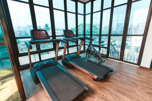 a gym with two exercise machines in a room with windows at Lanna Oriental Hotel in Chiang Mai