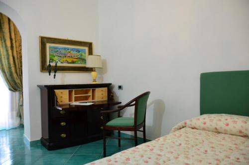 a bedroom with a desk and a chair next to a bed at Donna Alda Affittacamere Capitello dal 2012 in Villammare