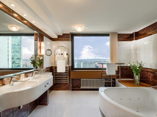 a bathroom with two sinks and a large window at Panorama Hotel Prague in Prague