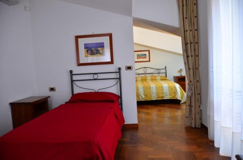 a bedroom with two beds and a red blanket at Donna Alda Affittacamere Capitello dal 2012 in Villammare