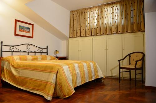 a bedroom with a bed and a chair at Donna Alda Affittacamere in Villammare