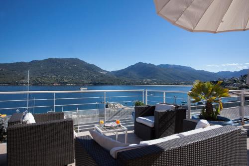 a balcony with chairs and a view of the water at Le Neptune & Spa in Propriano
