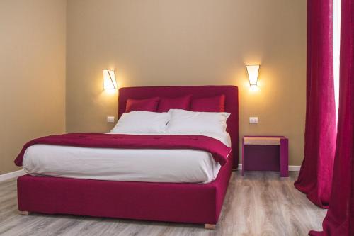 a bed with a red headboard in a room at Don Franco in Adelfia