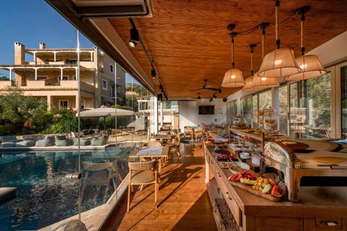 an outdoor restaurant with a pool and tables and chairs at Anthemion Suites and Villas in Nafplio