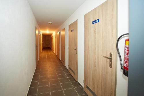 a corridor of a hospital hallway with a row of doors at Apartmany Arber in Železná Ruda