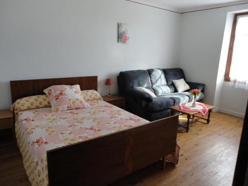 une chambre avec un lit et un canapé dans l'établissement Gite CLEVACANCES, à Laval-du-Tarn