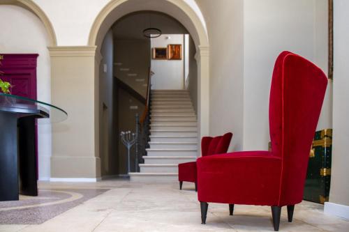 a red chair in a hallway with stairs at Don Franco in Adelfia
