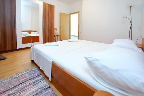 ビビニェにあるHoliday house Andrijaのベッド2台と鏡のある寝室