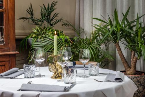 una mesa con una vela, vasos y plantas en Hotel Sleep-Inn Box 5, en Nijmegen