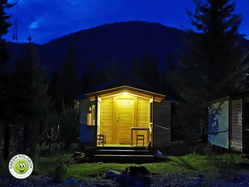 a small cabin with a yellow door at night at Eco-turbaza Green Kolobok in Aktash